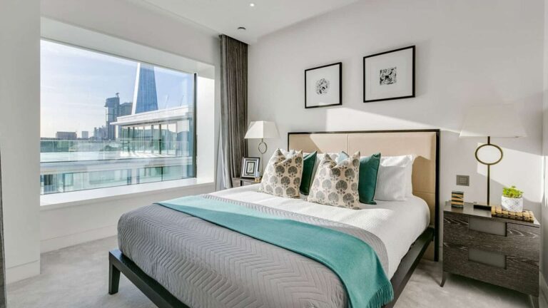 Modern bedroom with a large window with a view of London.