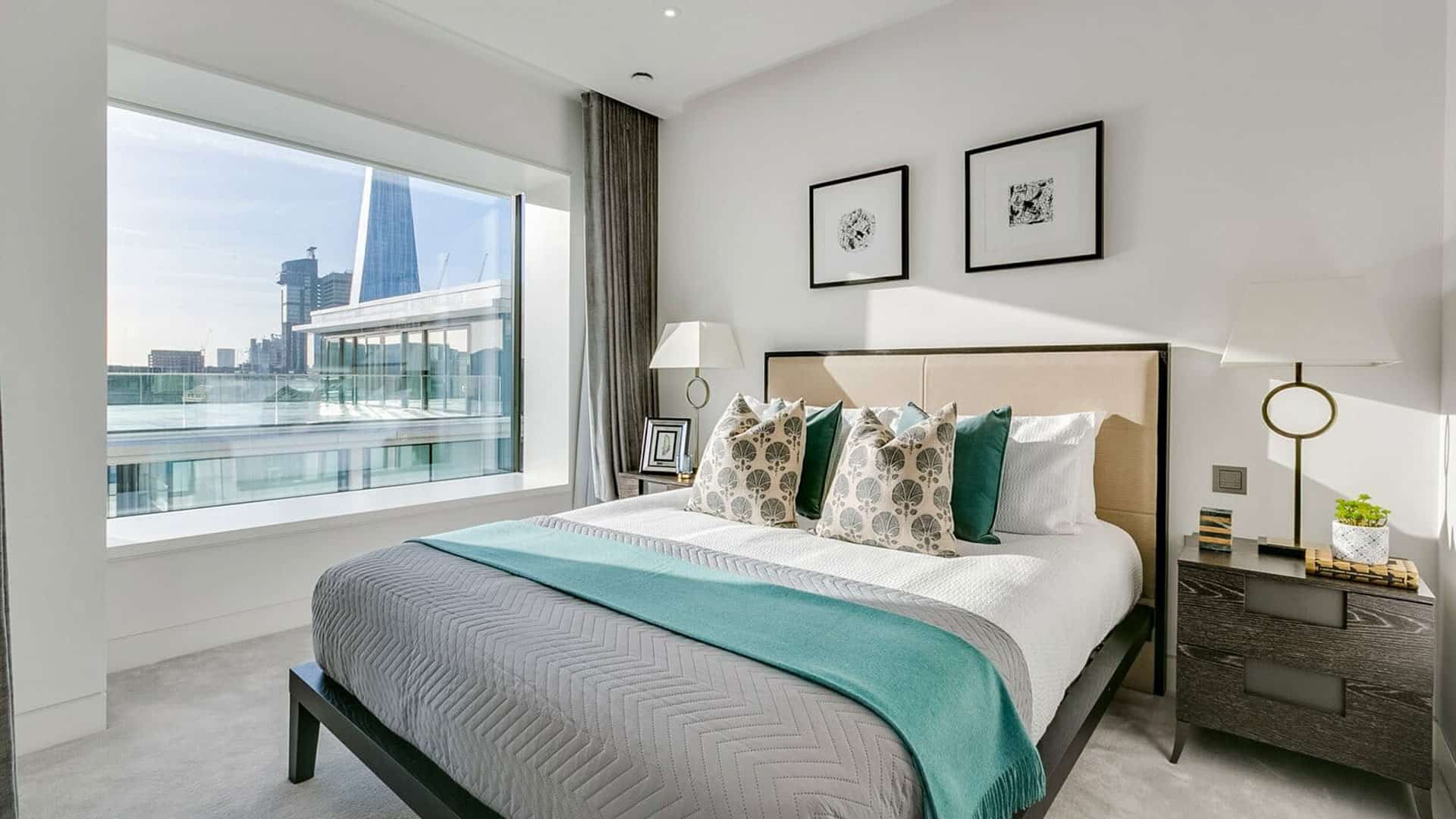 Modern bedroom with a large window with a view of London.